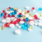Close up of colorful capsules and white tablets isolated