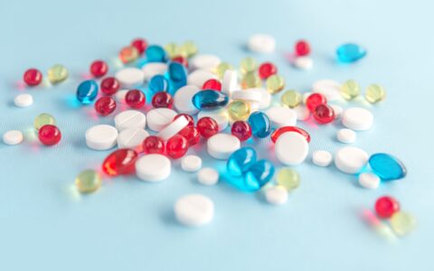 Close up of colorful capsules and white tablets isolated